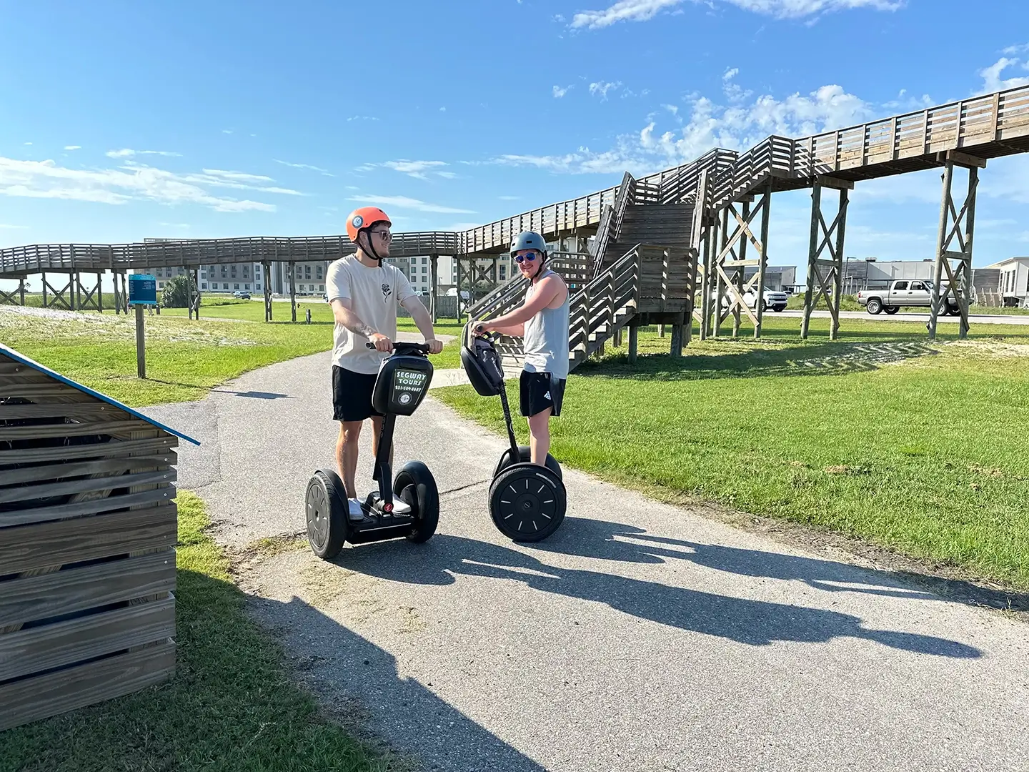 Two riders on Segways by bridge